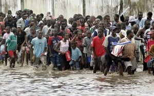 People braving torrential rain to see the Olympic Torch procession pass through Dar-es-Salaam