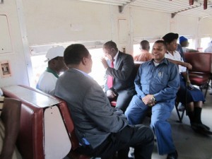 Minister of Transport, Dr. Harrison Mwakyembe (centre waving hand) accom­panied by officials from the Transportation Authority of Land Surface and Marine (Sumatra) on the first commuter train. Photo isaackin.blogspot